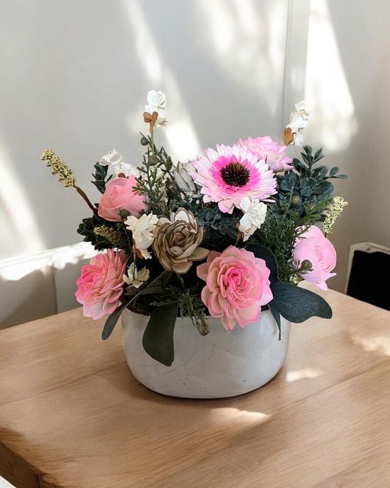 wooden flower arrangement with pink daisies and roses