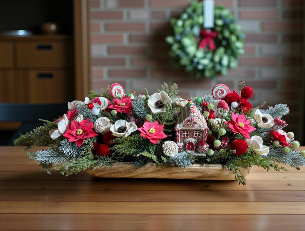 wooden christmas floral arrangement with gingerbread house