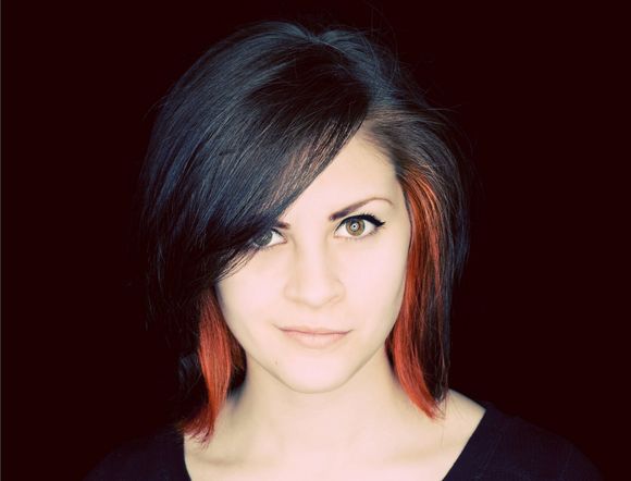 A woman with black and red hair is wearing a black shirt