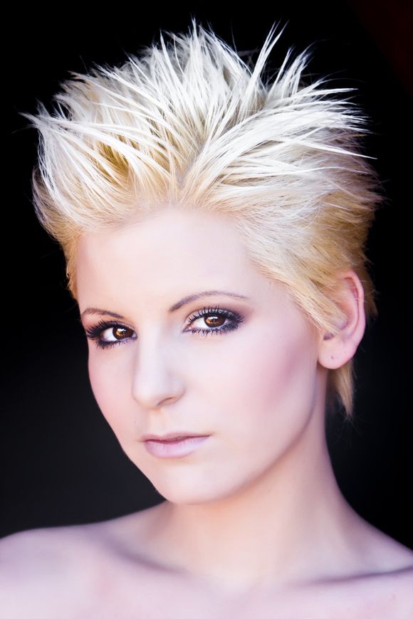 A close up of a woman 's face with short blonde hair