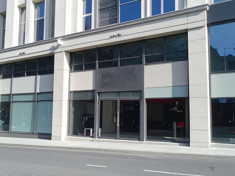 Modern storefront with large glass windows and double doors at street level