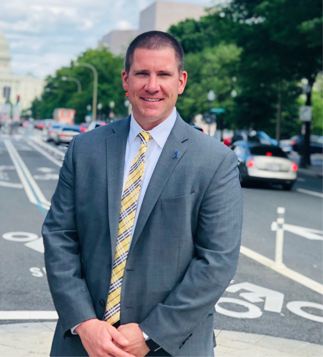 A man in a suit and tie is standing on a street