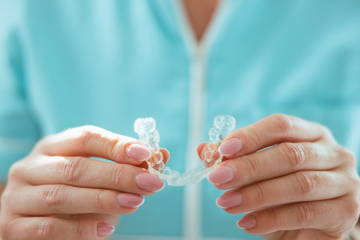 A woman is holding a clear brace in her hands.