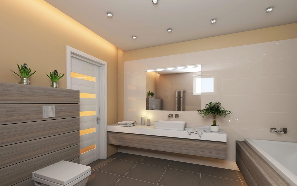 Bagno moderno con mobile lavabo, ampio specchio, vasca da bagno e pareti rivestite con piastrelle beige.