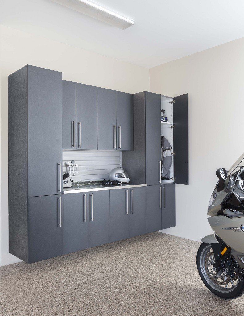 a a motorcycle parked in a garage with a silver garage cabinet systems