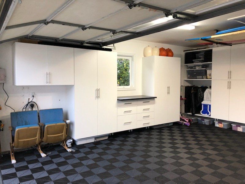 a white garage cabinet systems and a workbench
