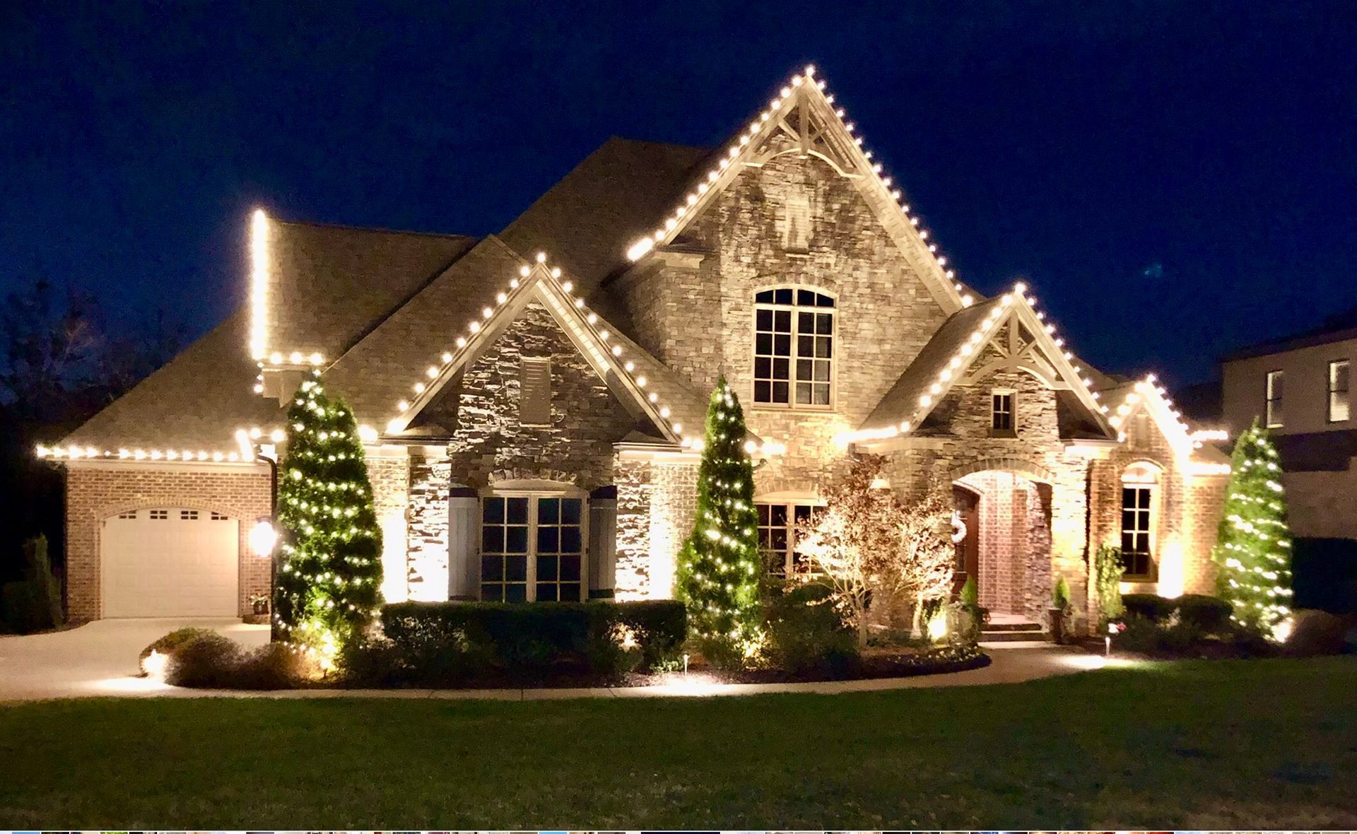 House decorated with white Christmas lights at night.