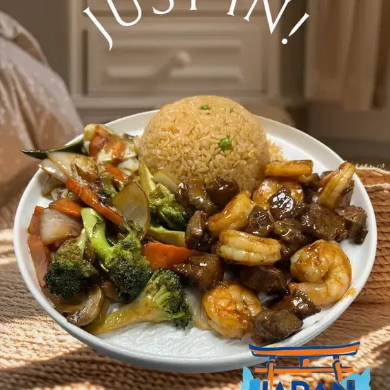 Plate of fried rice with shrimp, beef, and mixed vegetables on a table
