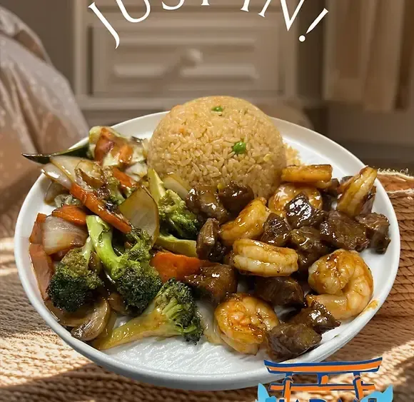 Plate of rice with beef, shrimp, and mixed vegetables in a home dining setting