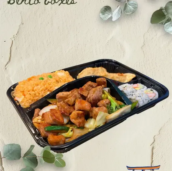 Takeout meal tray with grilled chicken, rice, vegetables, and salad on a light tabletop