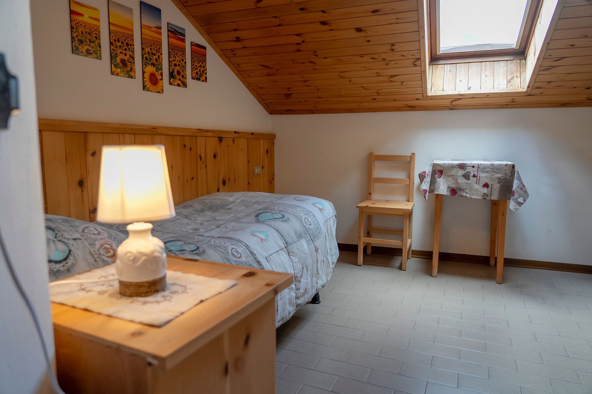 Una camera da letto con un letto, un comodino, un tavolo e una sedia.