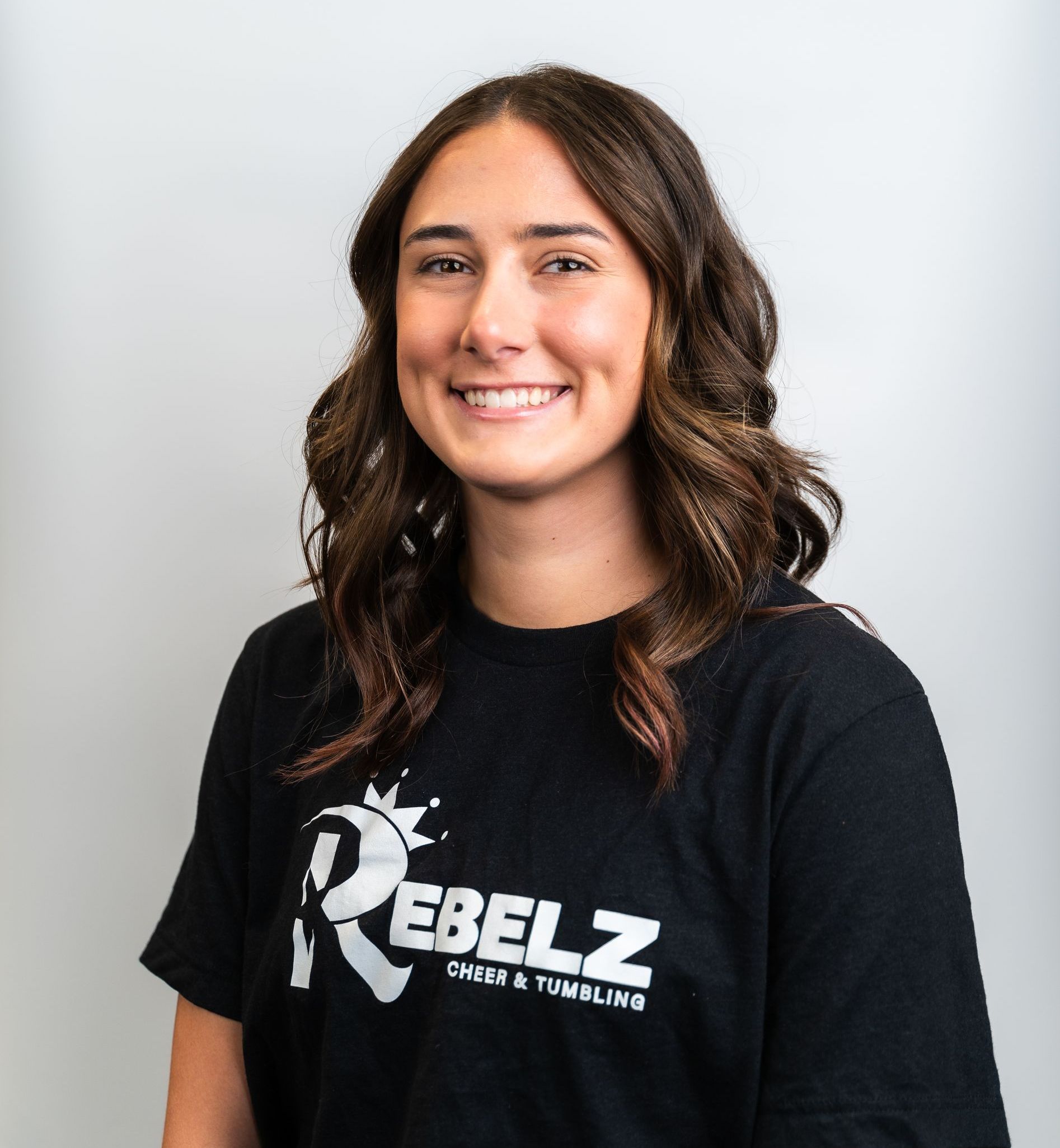 A woman wearing a black shirt with the letter r on it