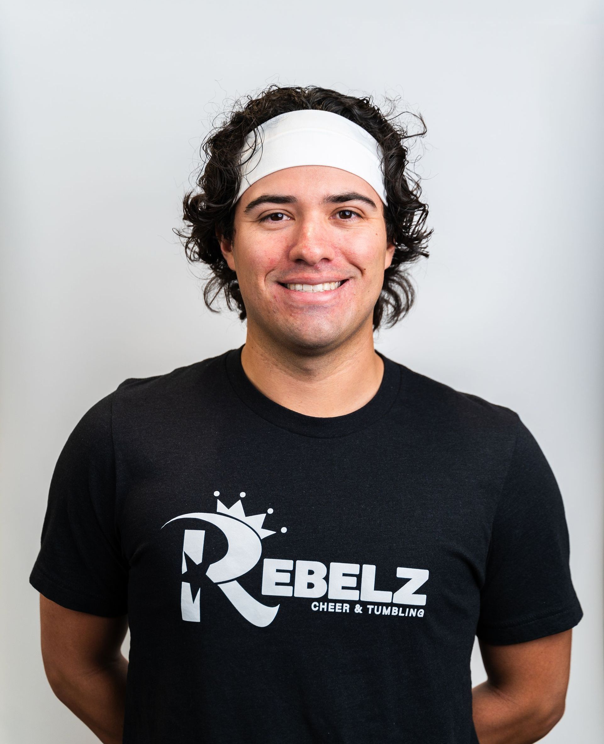 A man wearing a black shirt with the letter r on it