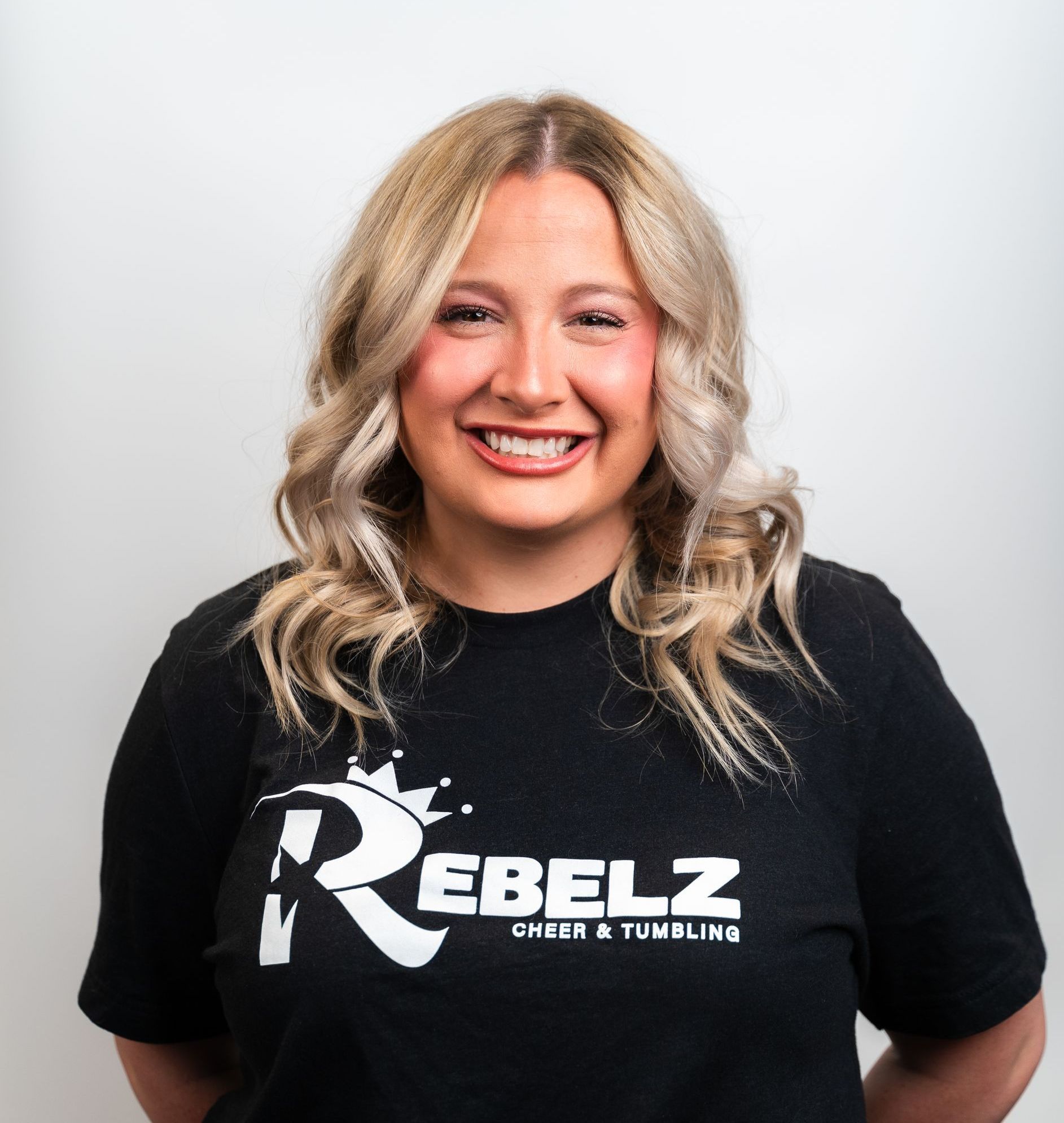 A woman wearing a black shirt with the letter r on it