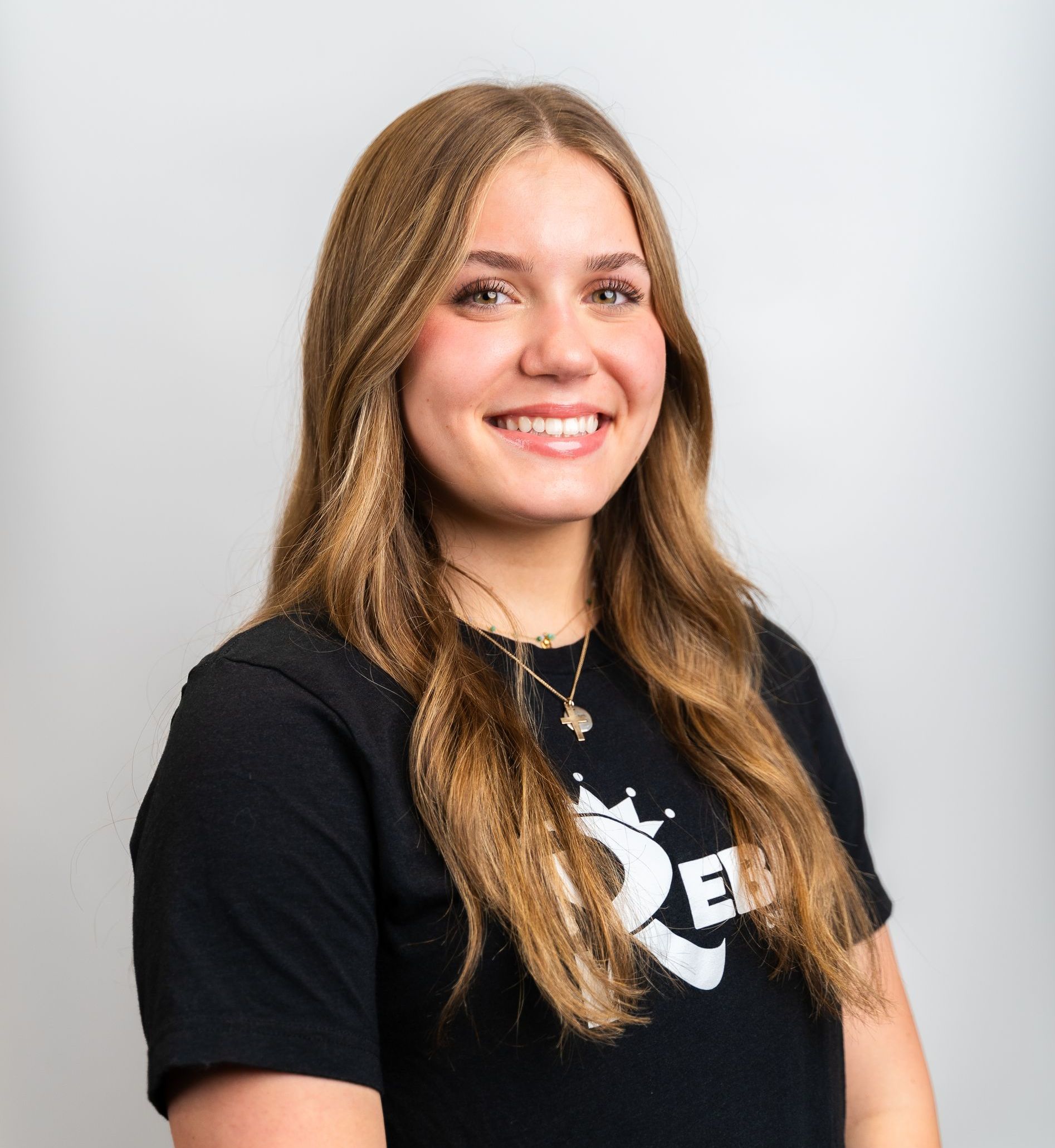 A woman wearing a black shirt with the letter r on it
