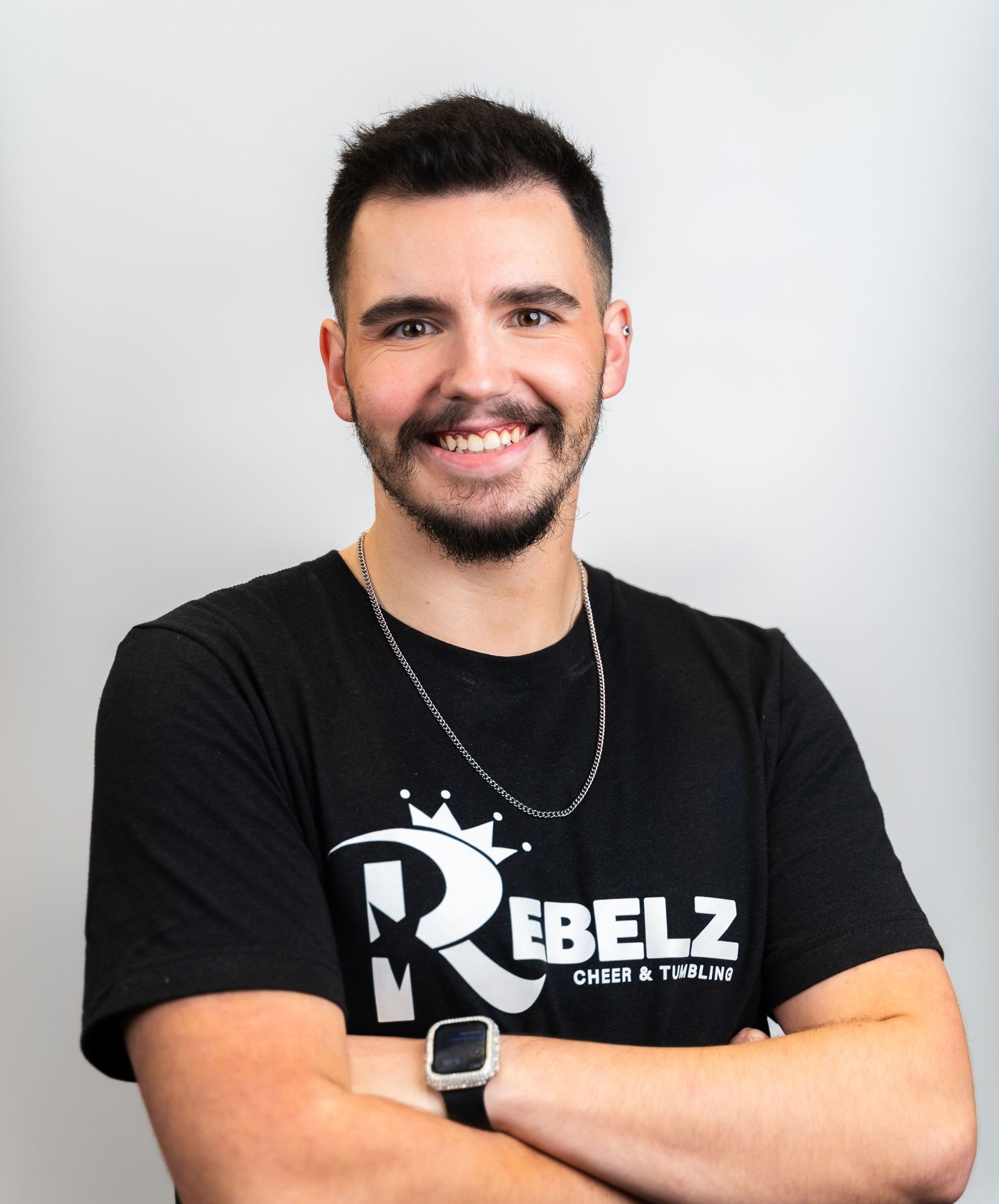 A man wearing a black shirt with the letter r on it