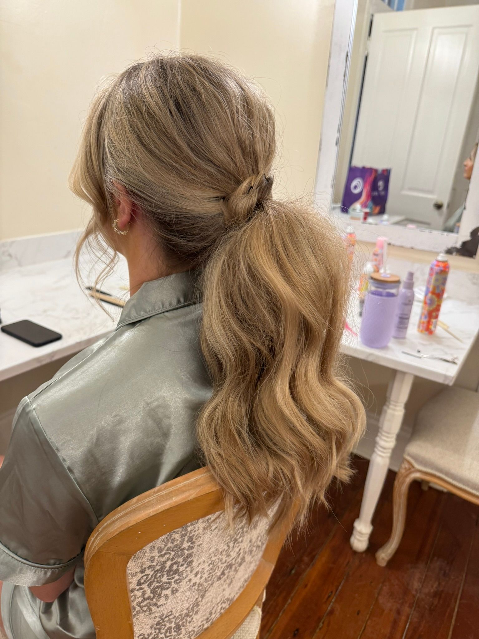 A woman is sitting in a chair with her hair in a ponytail