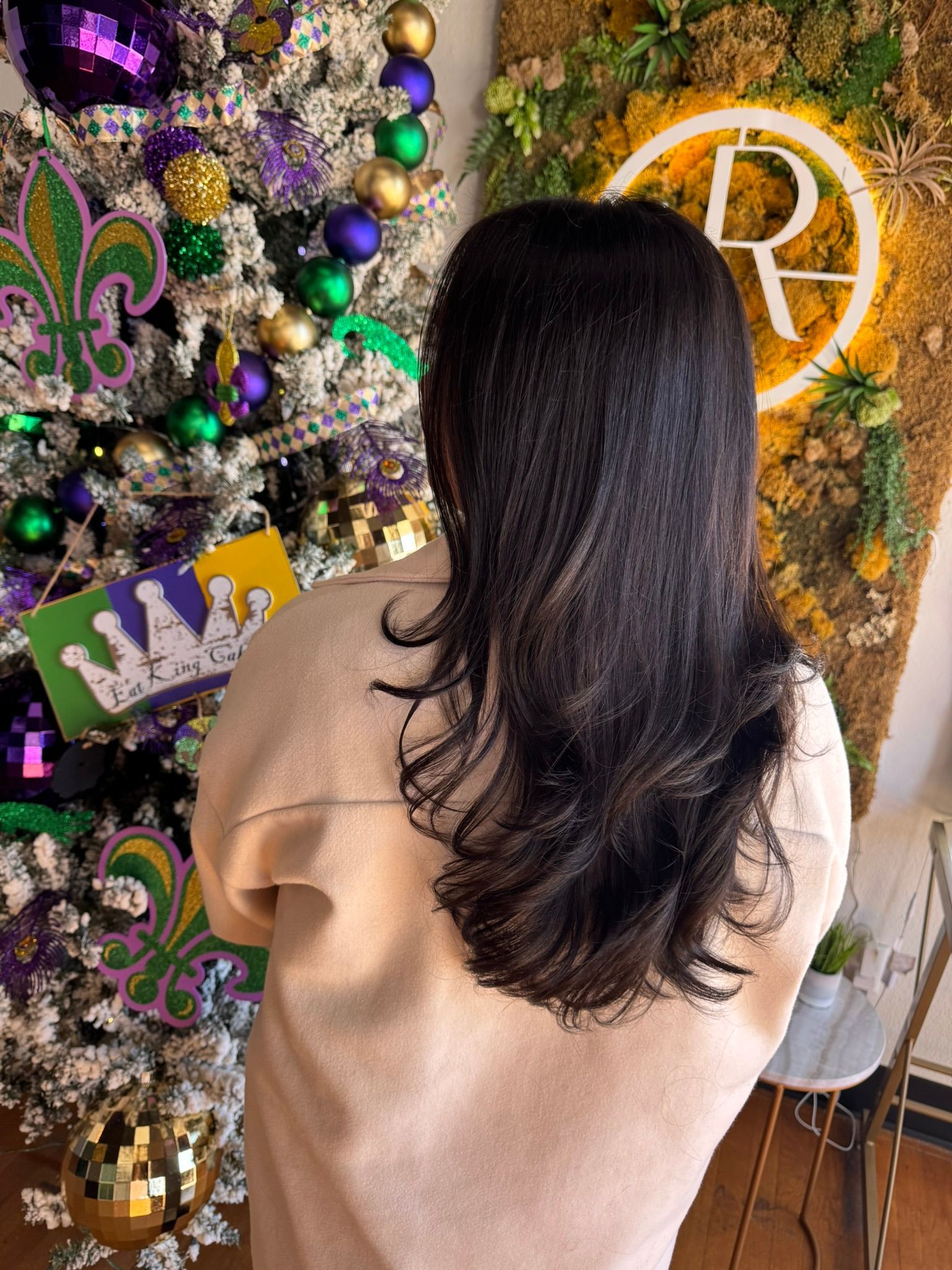 A woman is standing in front of a christmas tree