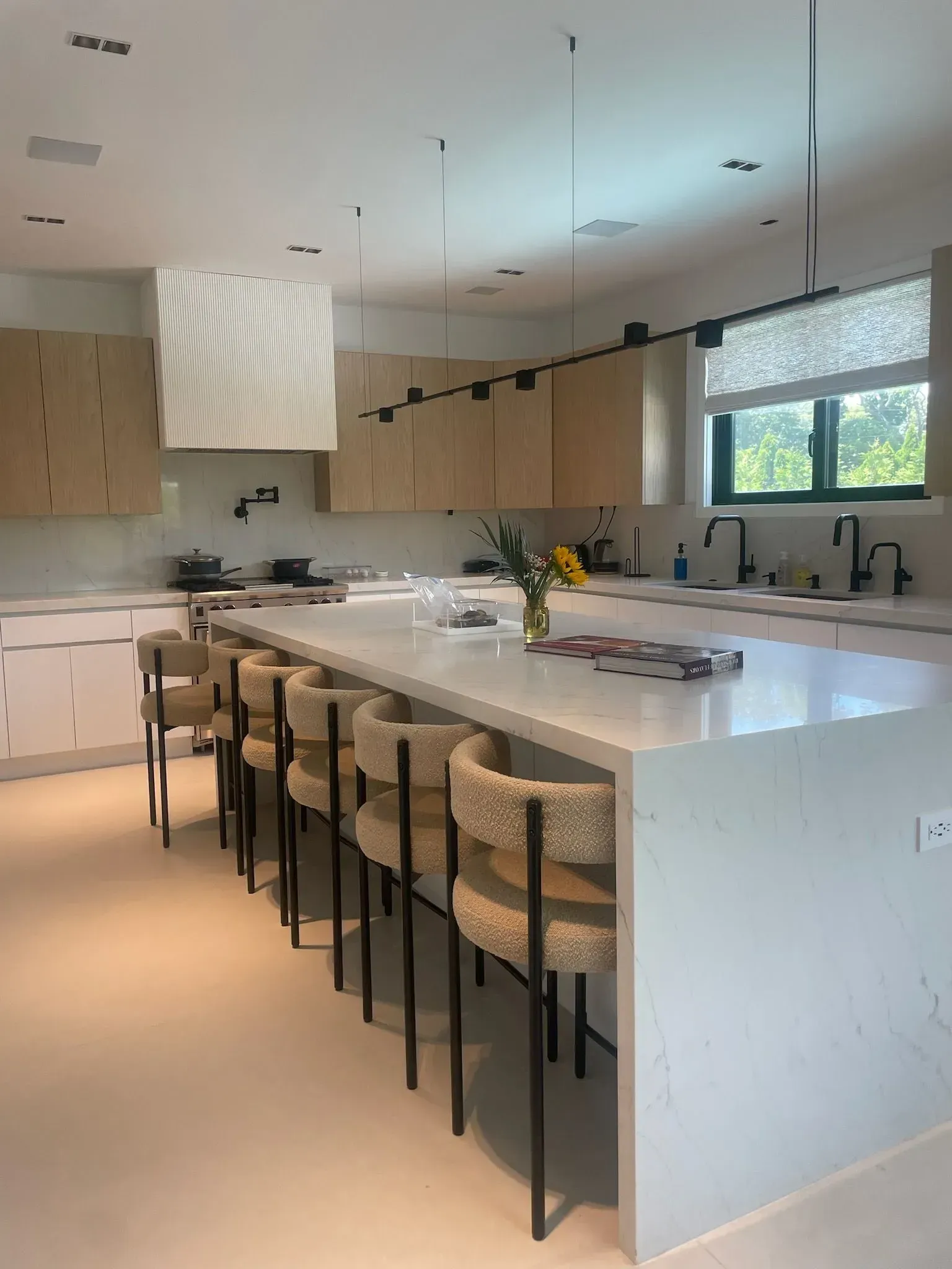 A kitchen with a large island and chairs