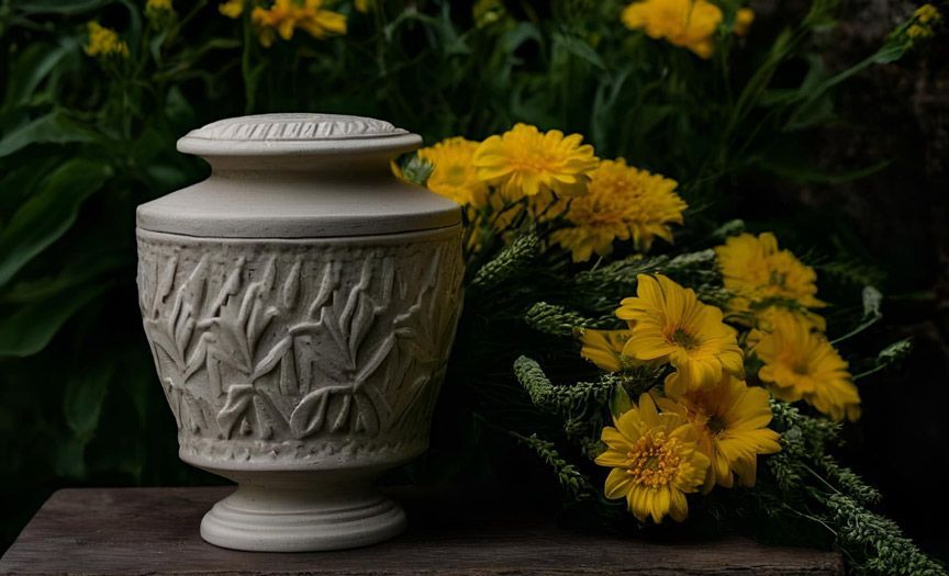 urn beside yellow flowers cremation services Phoenix, AZ
