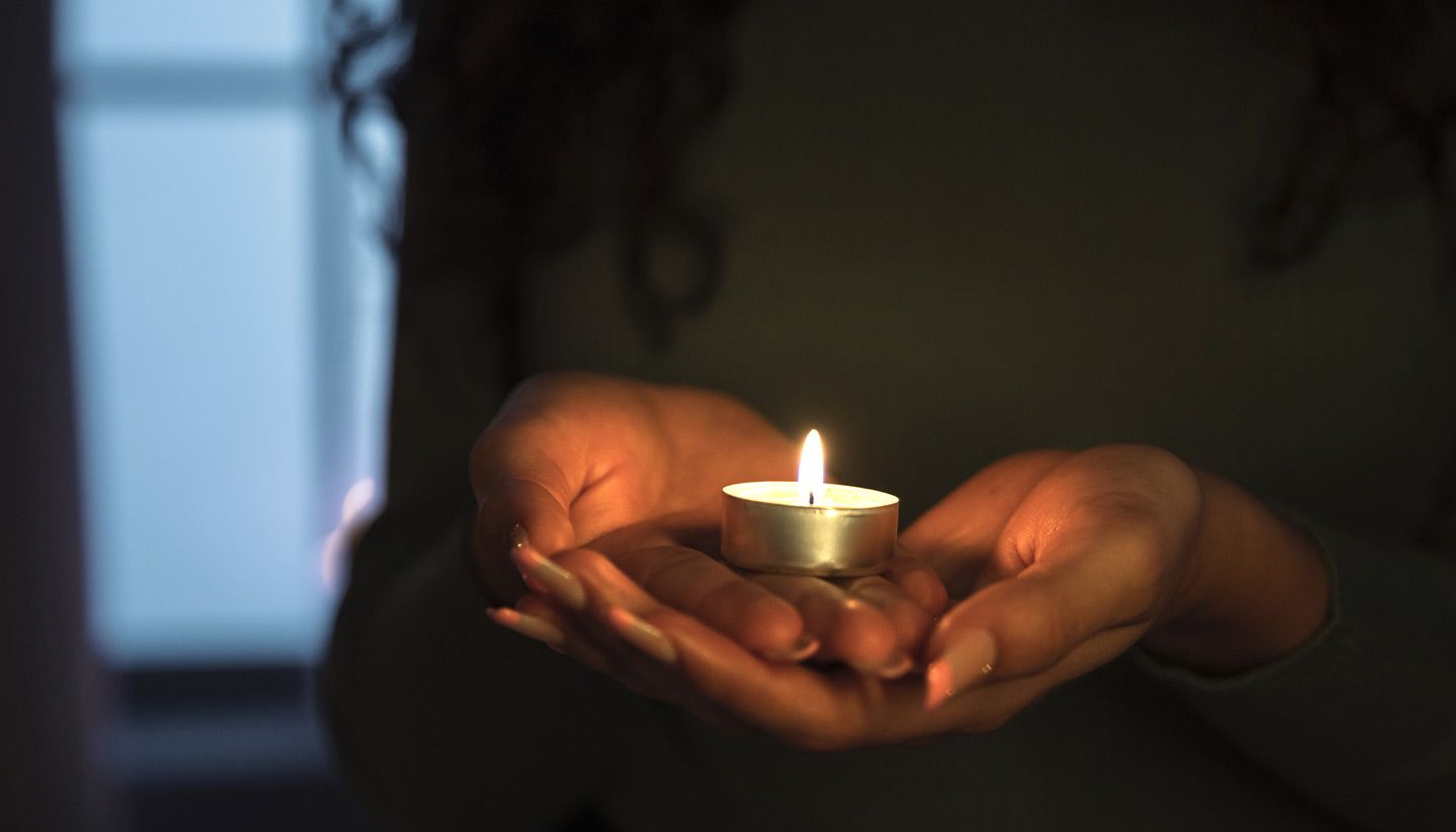 woman holding a candle, cremation services Phoenix, AZ