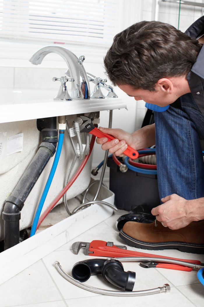 Man Fixing Sink Pipes