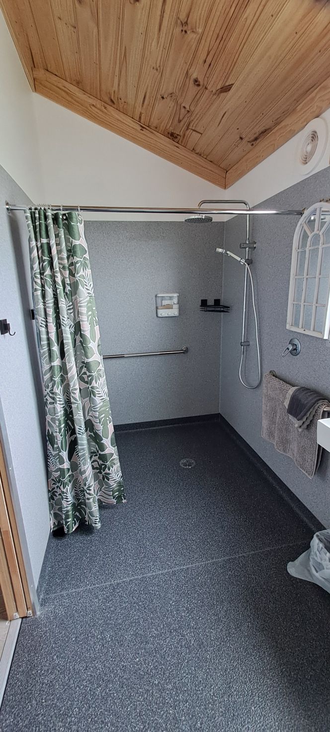 A bathroom with a walk in shower and a sink.