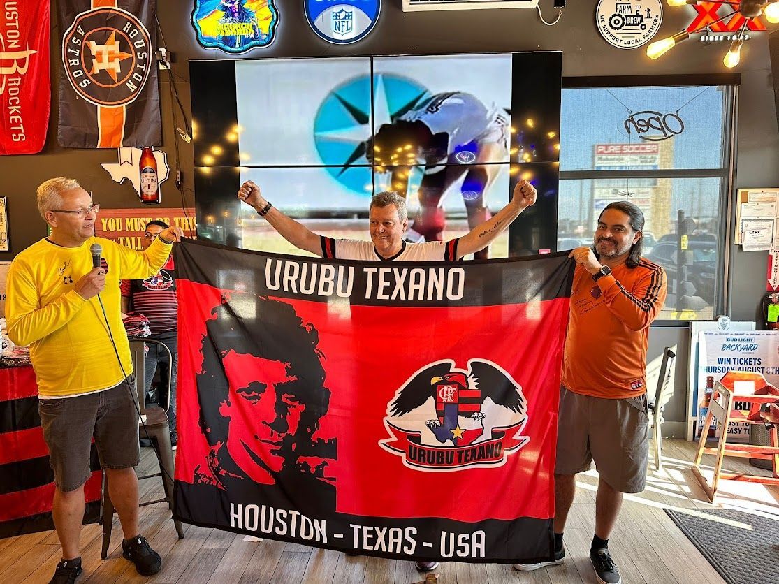 Three men are holding a flag that says urubu texano houston texas usa