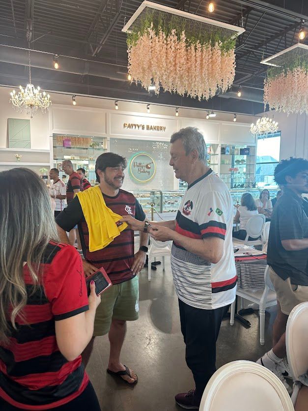 A group of people are standing in a restaurant talking to each other.