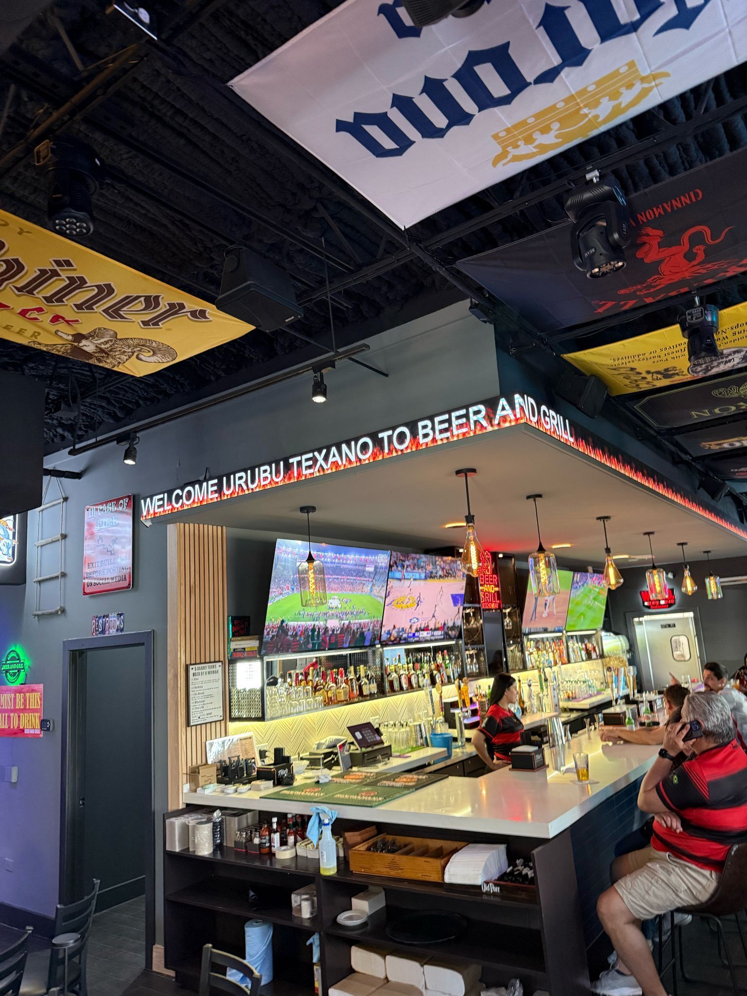 A group of people are sitting at a bar in a restaurant.