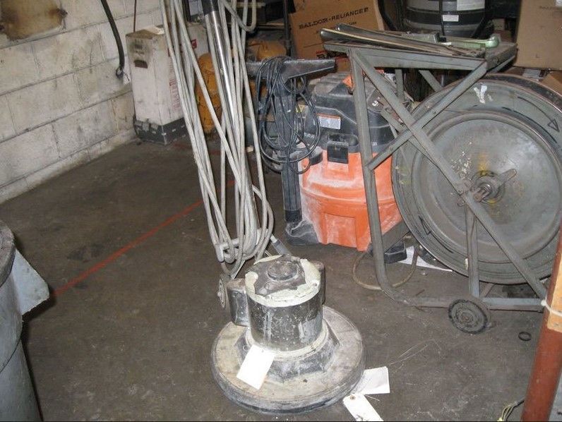 A vacuum cleaner is sitting on the floor in a garage