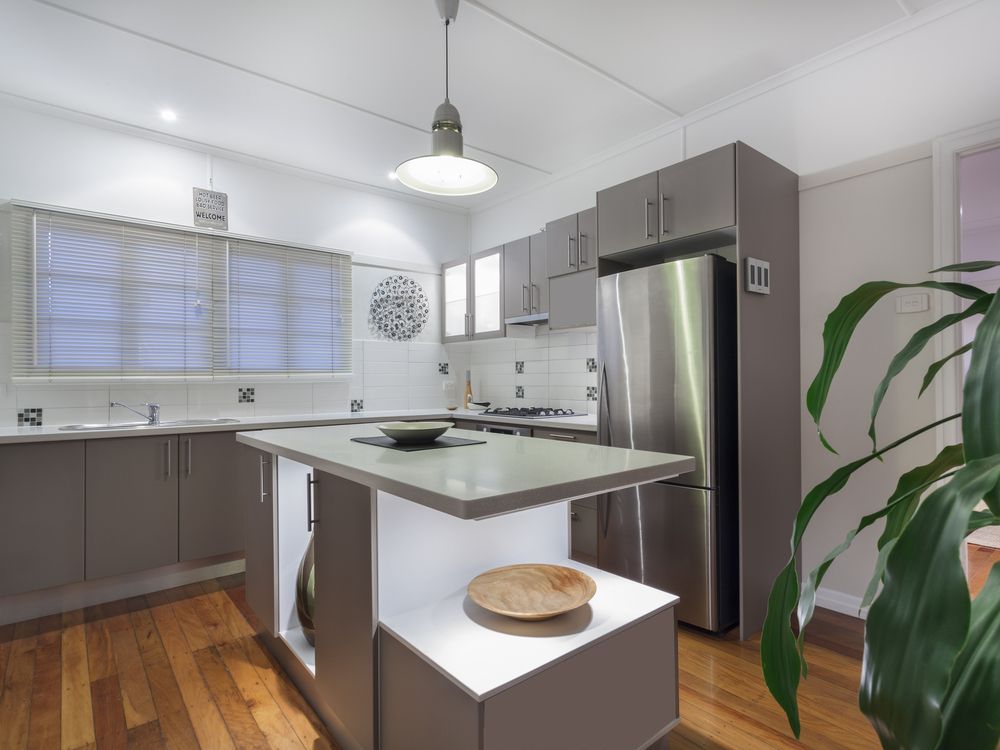 A Kitchen With Stainless Steel Appliances and a Large Island in the Middle — Hunter Kitchen King In Huntlee, NSW