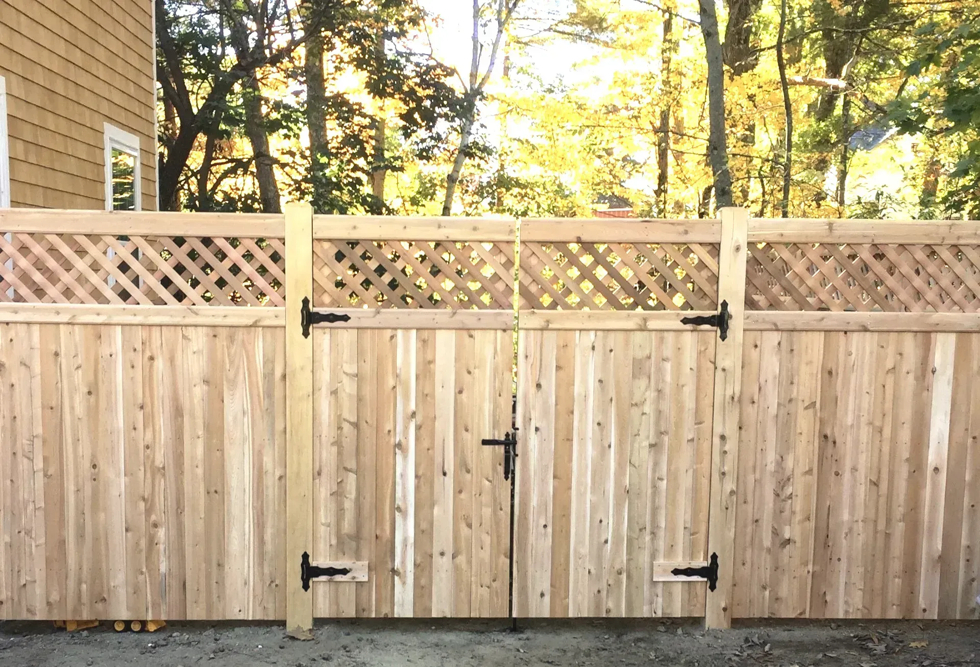 A wooden fence with a gate in front of a house