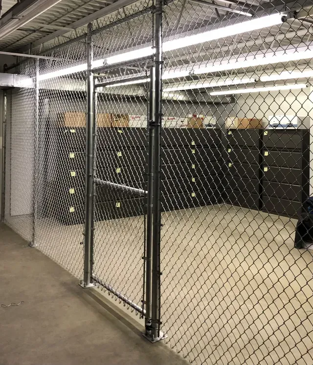 A room with a chain link fence and a door.