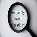 Magnifying glass over the words “Frequently asked Questions” on a light background