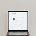 Open laptop on a desk displaying a white webpage interface