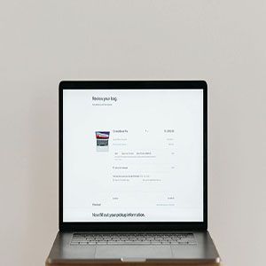 Open laptop on a desk displaying a white webpage interface