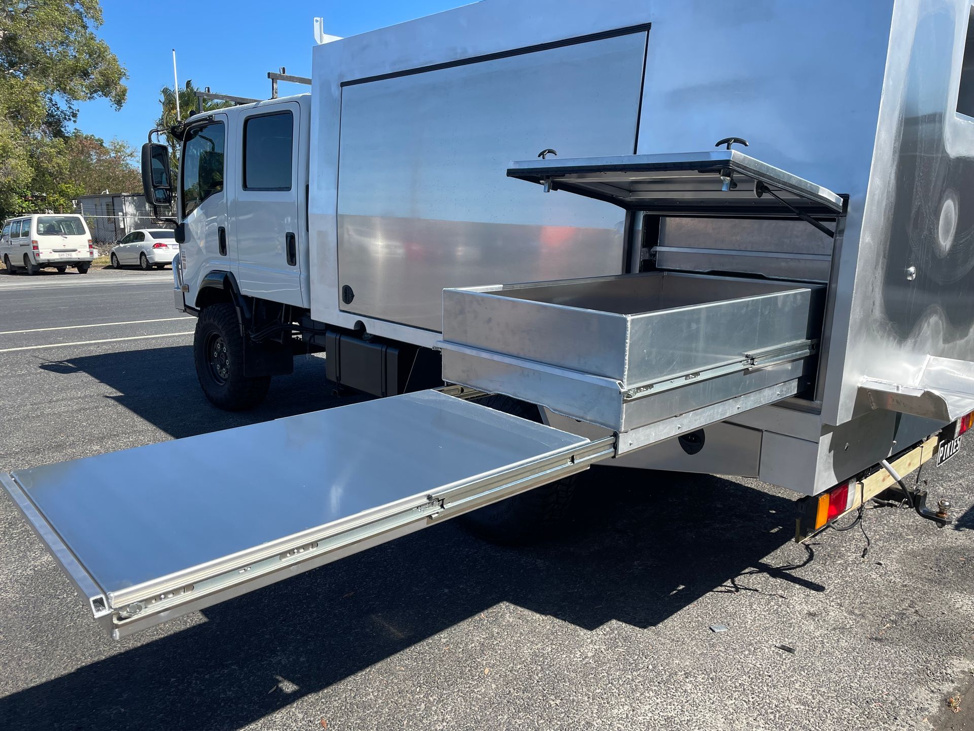 Silver truck with a pull-out table and side compartment open on a sunny day. — Boyd's Fabrications In Portsmith, QLD
