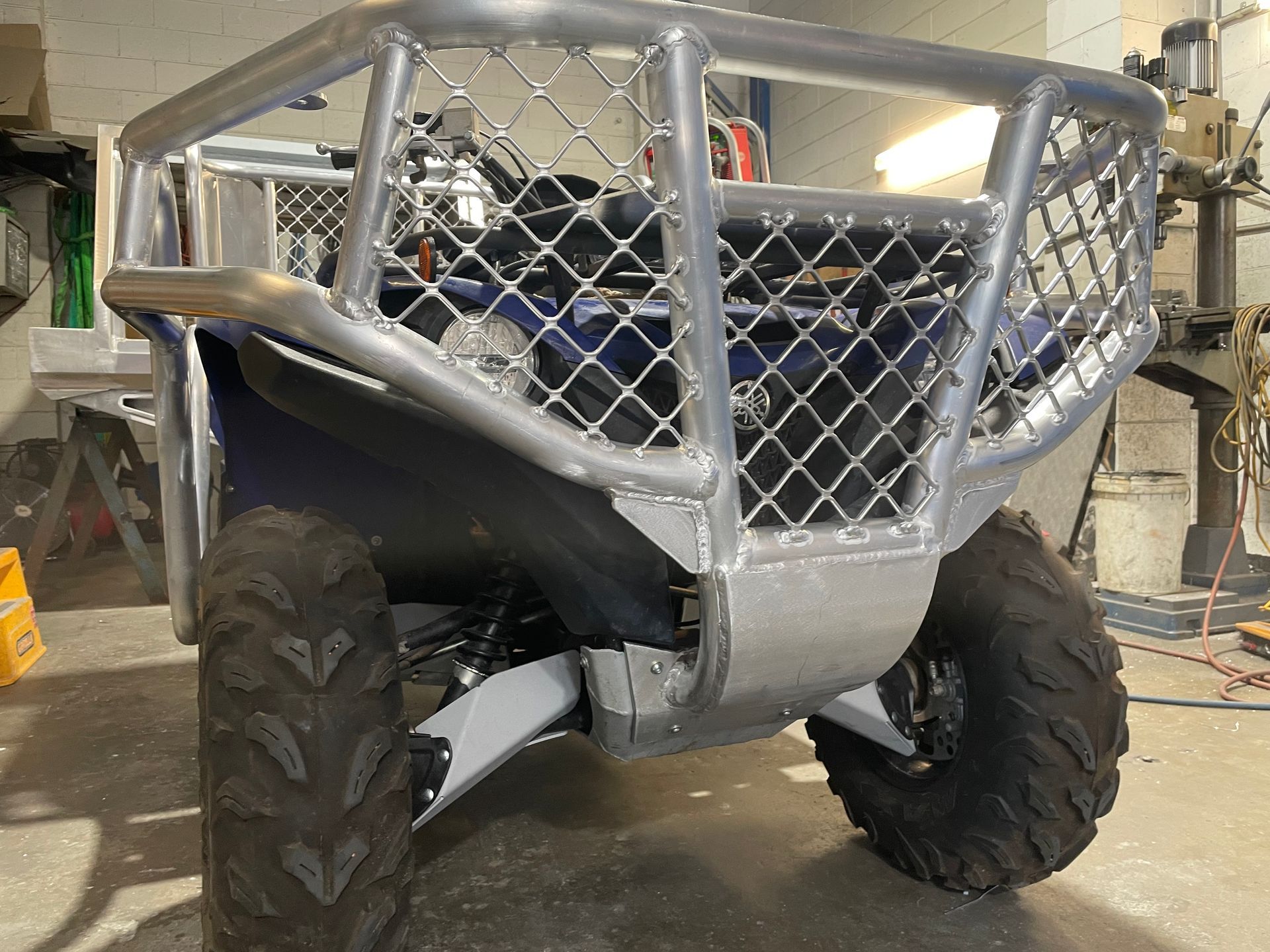 Blue ATV with silver roll cage and black tires in a workshop. — Boyd's Fabrications In Portsmith, QLD