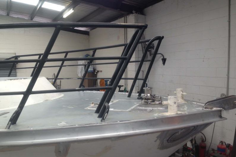 A Boat is Sitting in a Warehouse With a Black Railing — Boyd's Fabrications In Mt. Isa, QLD