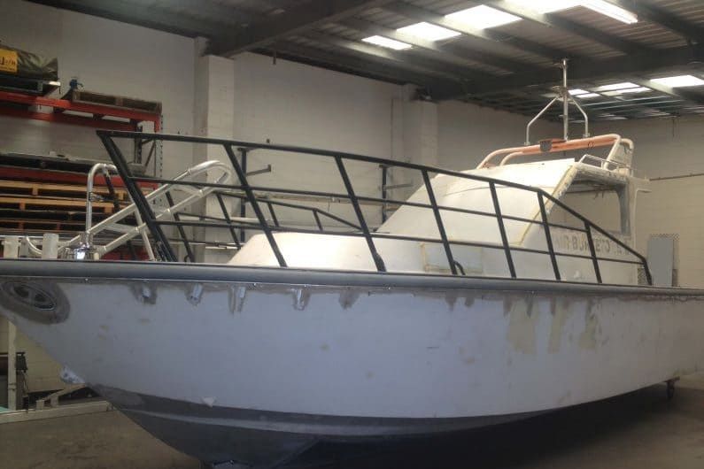 A Boat is Sitting in a Warehouse With a Black Railing — Boyd's Fabrications In Smithfield, QLD