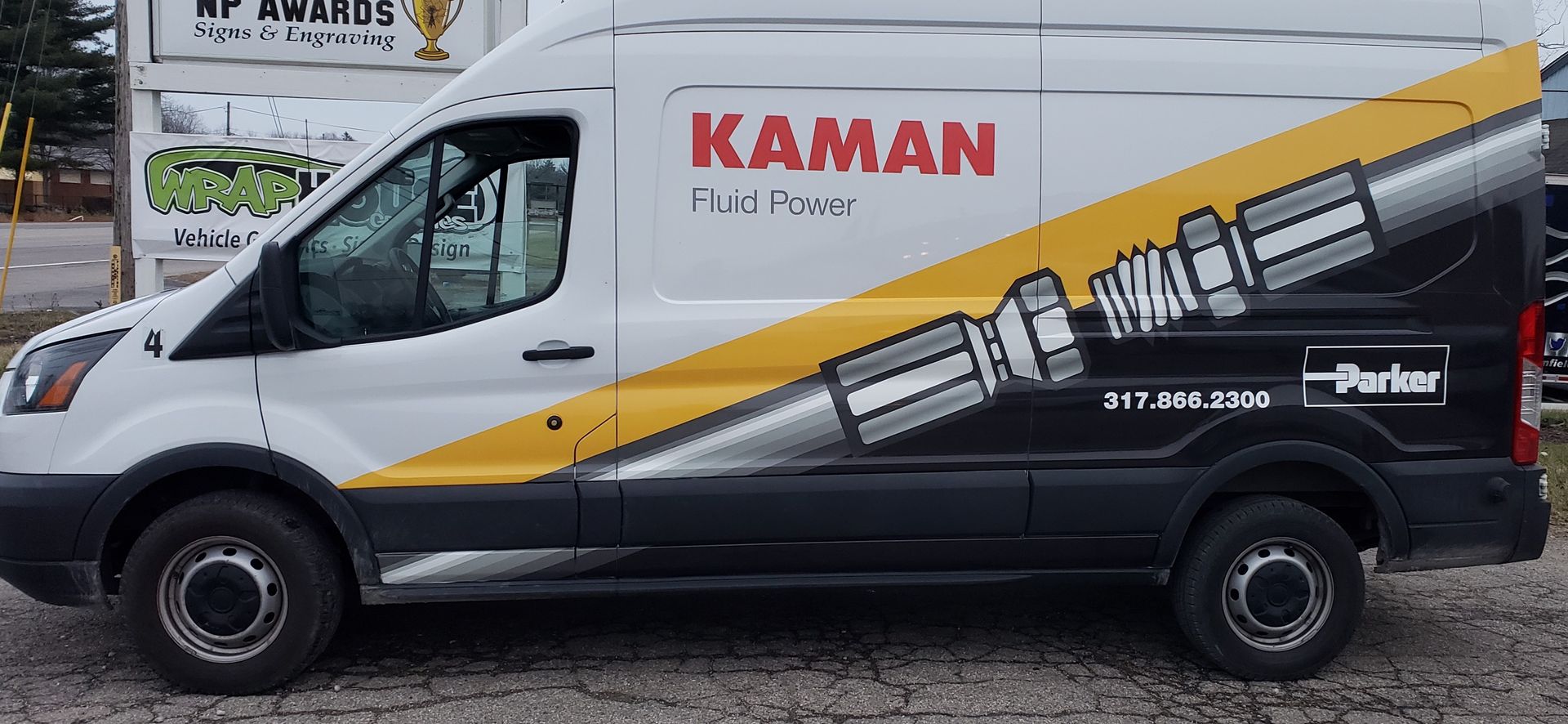 White Kaman Fuel Power van with black and yellow graphics, parked on a surface.