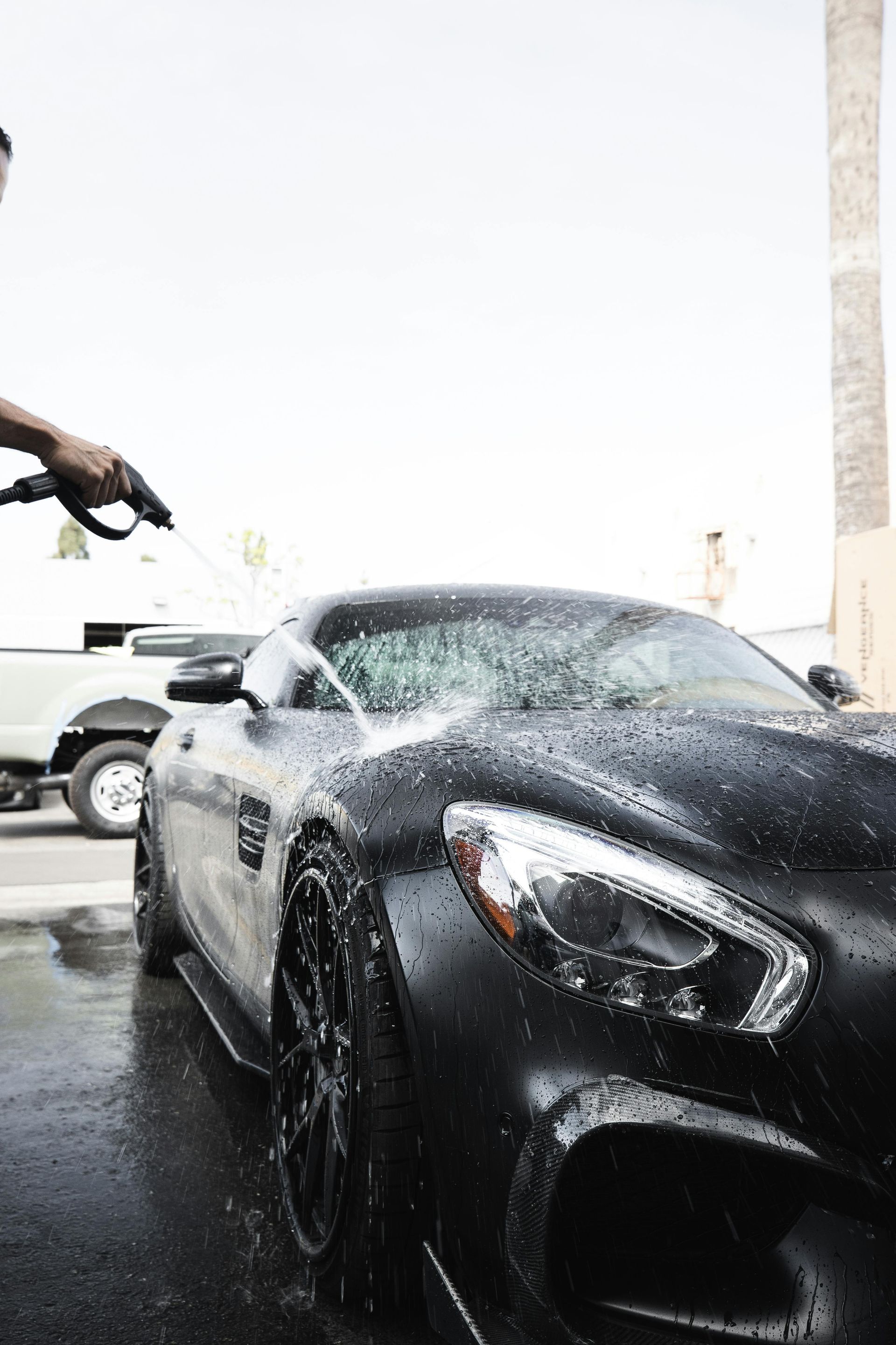 Black sports car being washed with water.
