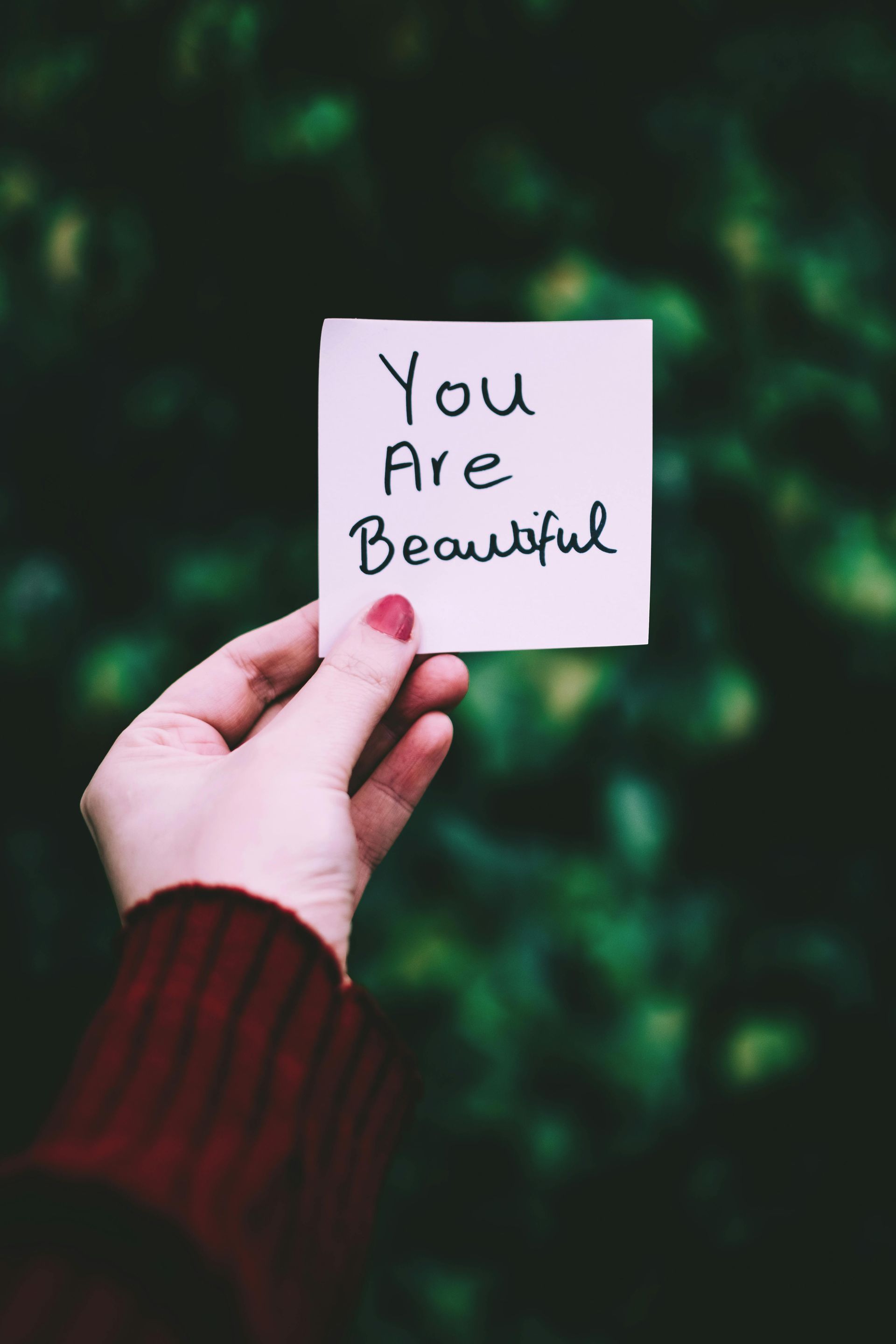 Hand holding a sticky note that says