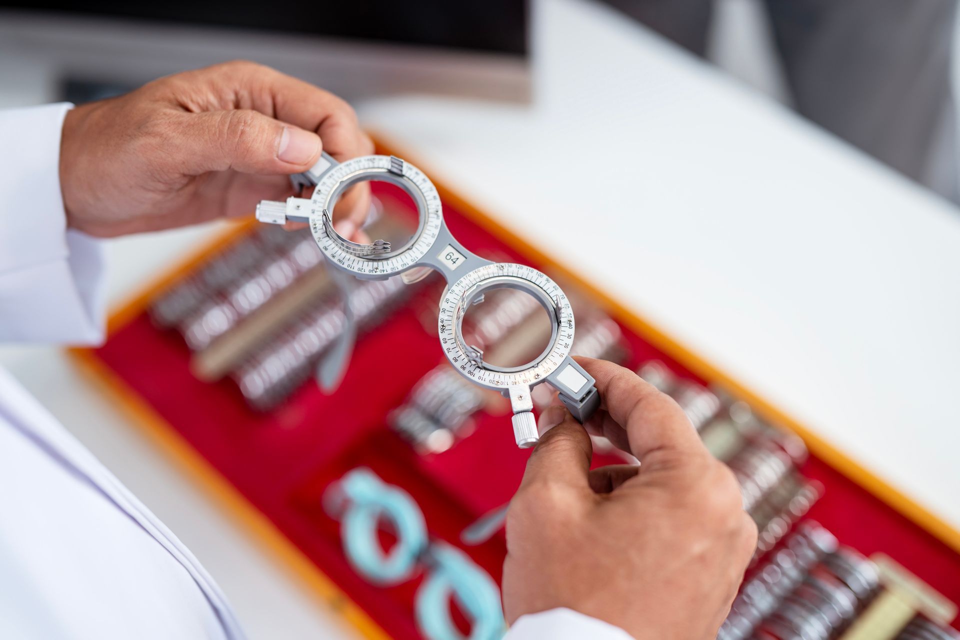 A doctor is holding a pair of glasses in his hands.