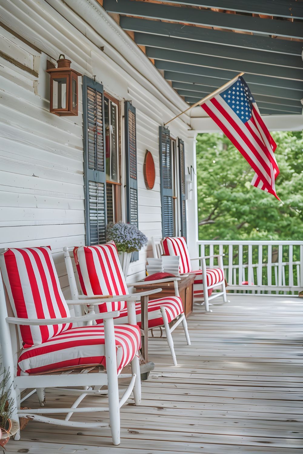 Porch with red-and-white striped chairs and an American flag hanging on a white house