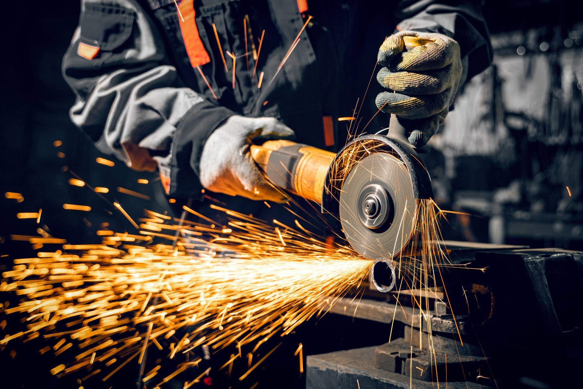 A man is grinding a piece of metal with a grinder.