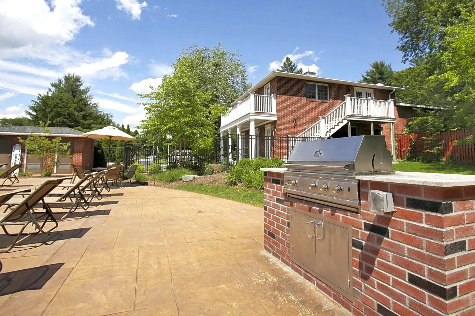 Outdoor grilling area with lounge seating and landscaped courtyard at Waltham Overlook Apartments in Waltham, MA.