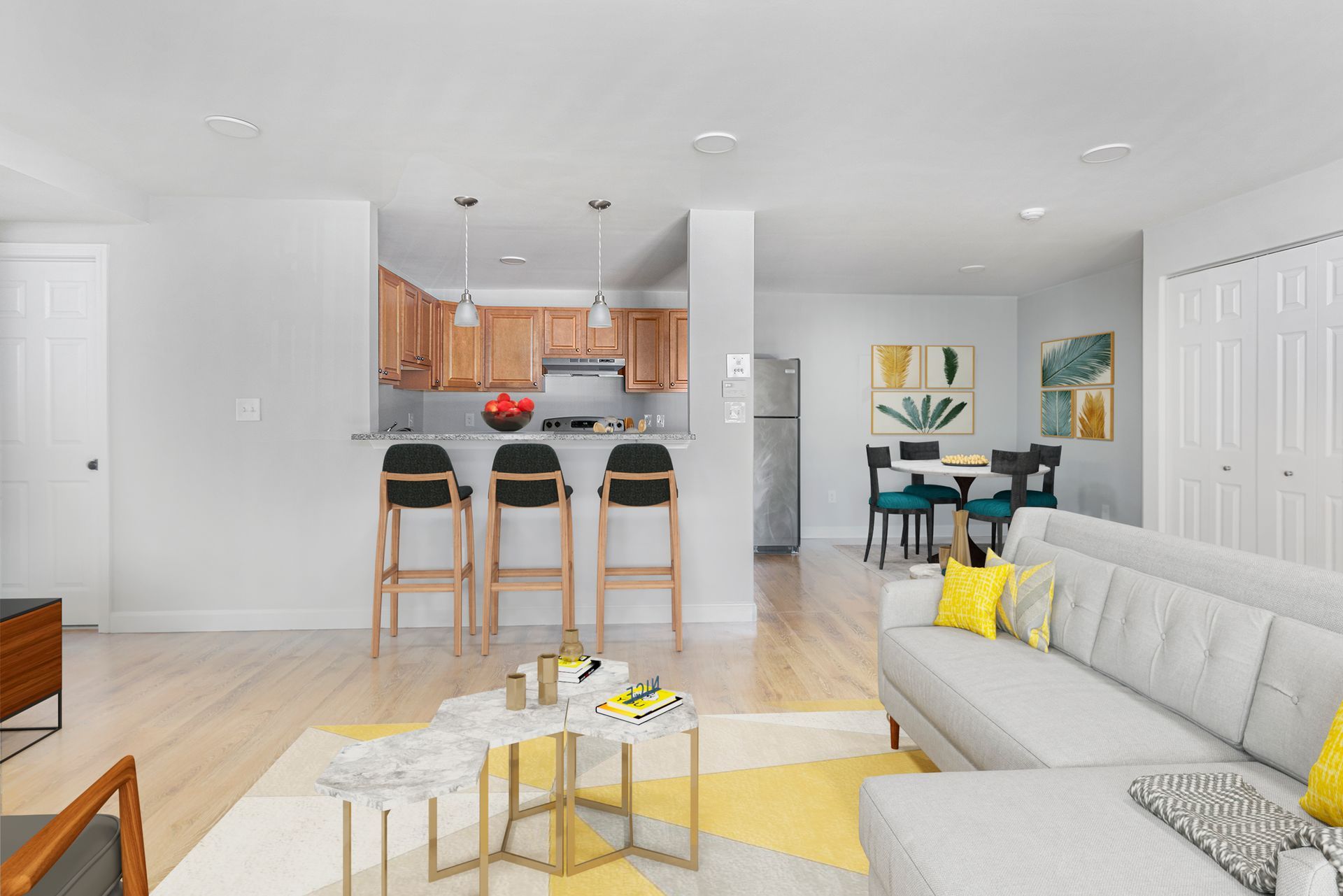 Open-concept apartment with living room, dining area, and kitchen with wood cabinets at Waltham Overlook Apartments in Waltham, MA.