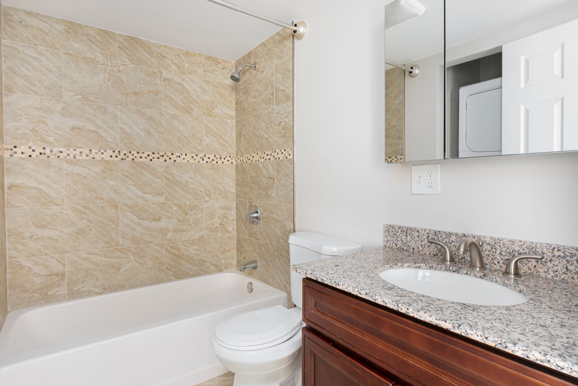 Bathroom with bathtub, tiled shower, and granite vanity at Waltham Overlook Apartments in Waltham, MA.